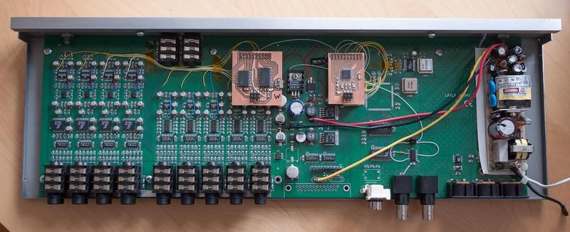 top view of the interface box with the cover removed, showing the
main circuit board with added wires and circuit boards with the
microcontroller and ADAT chips