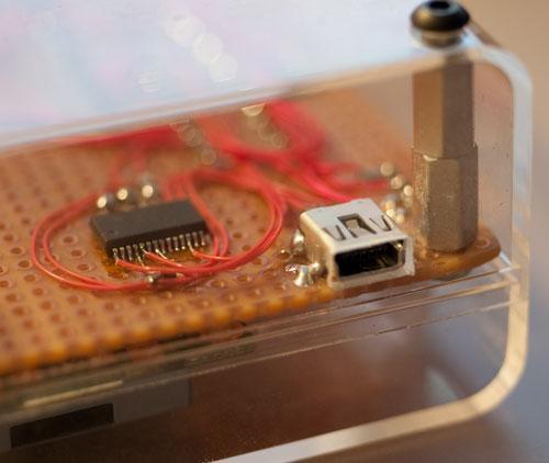 photo through the clear plastic case showing the USB jack and the FTDI
chip, with little wires soldered to the pins